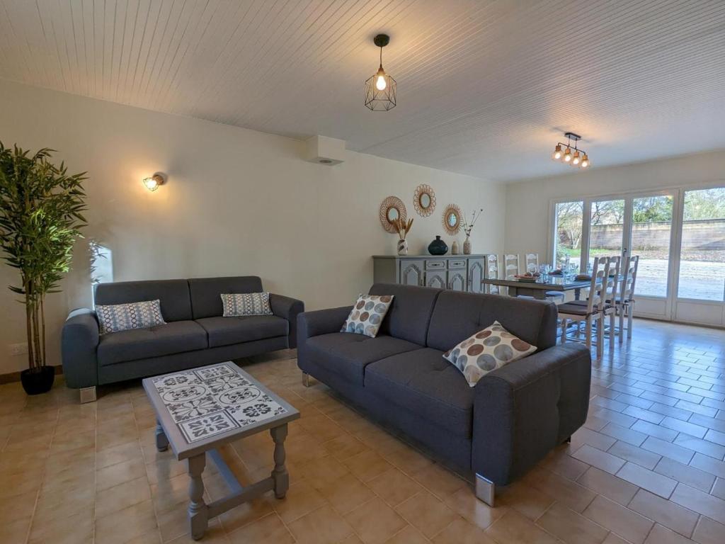 a living room with two couches and a table at Gîte Puyréaux, 4 pièces, 5 personnes - FR-1-653-227 in Puyréaux