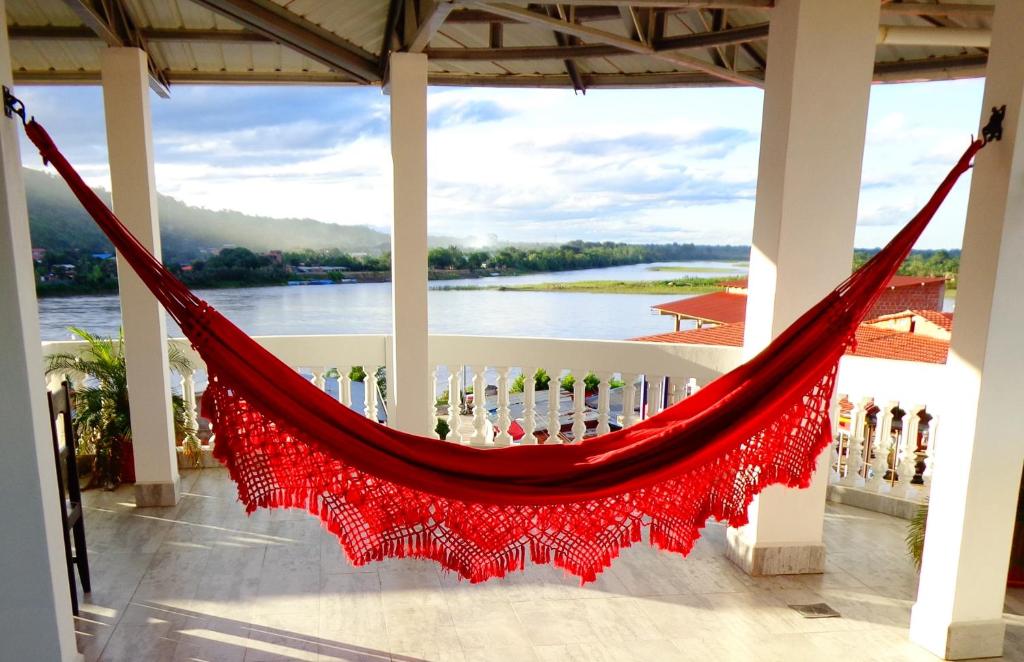 a hammock on a porch with a view of a river at Pampa & Selva in Rurrenabaque