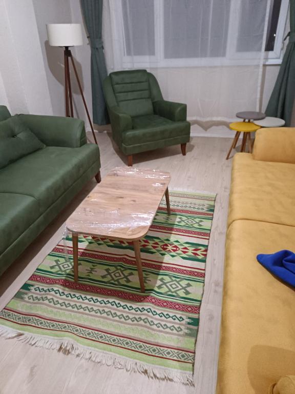 a living room with two green couches and a coffee table at daily rental apartment 5 minutes to the airport in Pazar