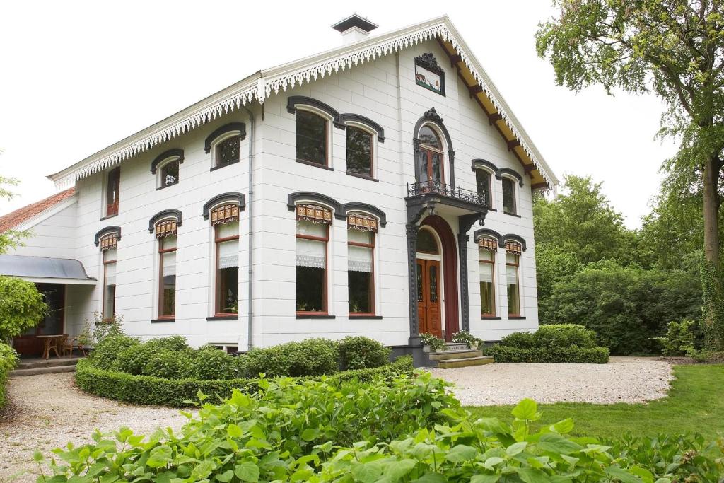 una casa blanca con una puerta roja en Graanzicht, en Midwolda