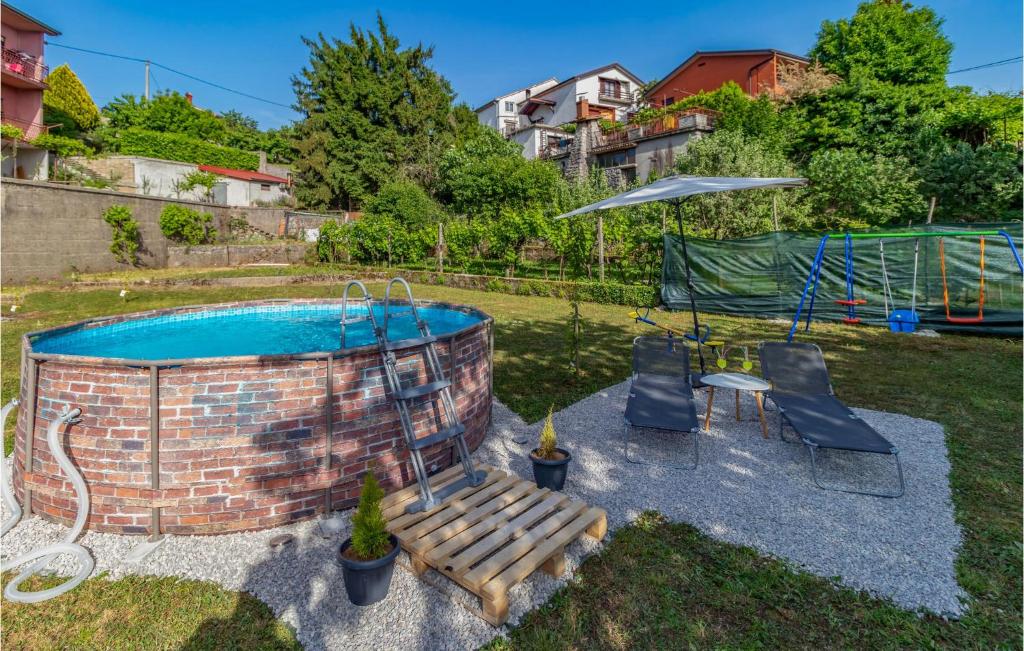 a pool in a yard with a bench and an umbrella at 2 Bedroom Gorgeous Apartment In Viskovo in Viskovo