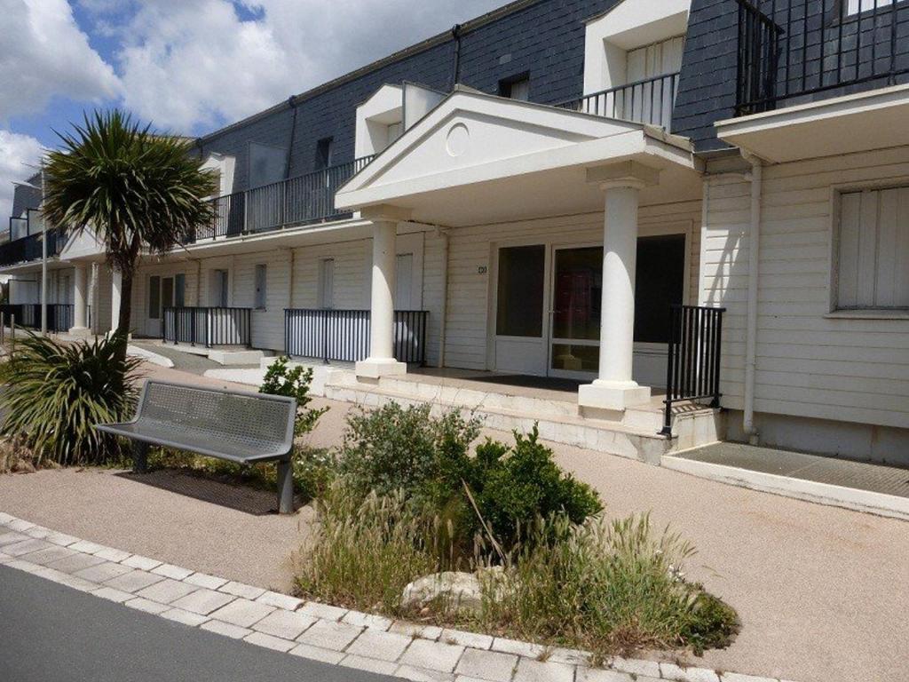 un banc assis devant un bâtiment dans l'établissement Agréable T2 proche plage à Saint-Gilles-Croix-de-Vie avec garage privé - FR-1-224-140, à Saint-Gilles-Croix-de-Vie