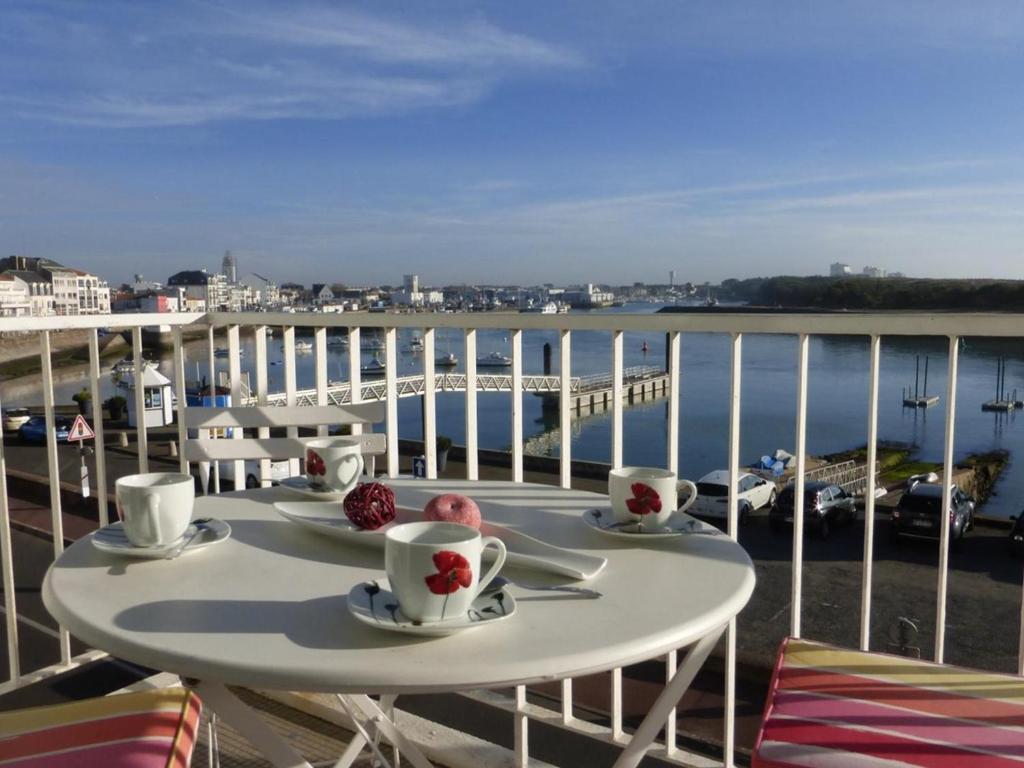 une table sur un balcon avec vue sur l'eau dans l'établissement Appart 2 pièces 5 pers avec parking à 500m de la plage - Saint-Gilles-Croix-de-Vie - FR-1-224-44, à Saint-Gilles-Croix-de-Vie