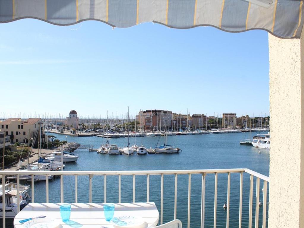 un balcon avec vue sur une marina avec des bateaux dans l'établissement Apt famille 6 pers avec terrasse, parking et lave-linge à Gruissan - FR-1-229-630, à Gruissan