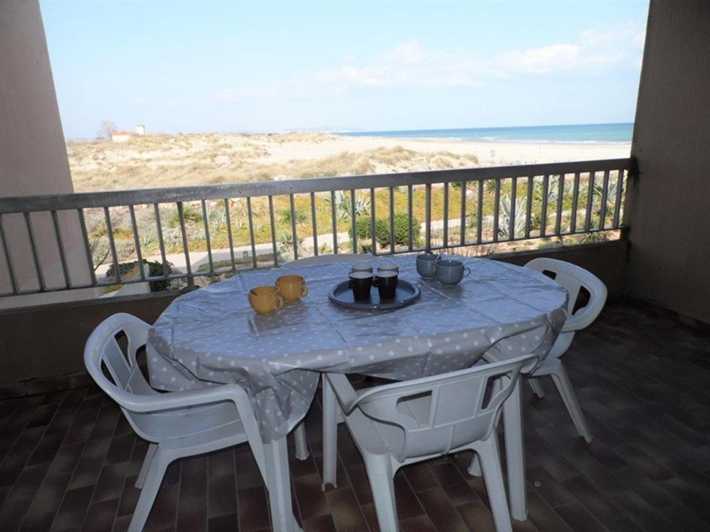 une table et des chaises sur un balcon avec la plage dans l'établissement Bel appartement 2 pièces avec parking et vue mer, 4/5 couchages - FR-1-326-515, à Marseillan