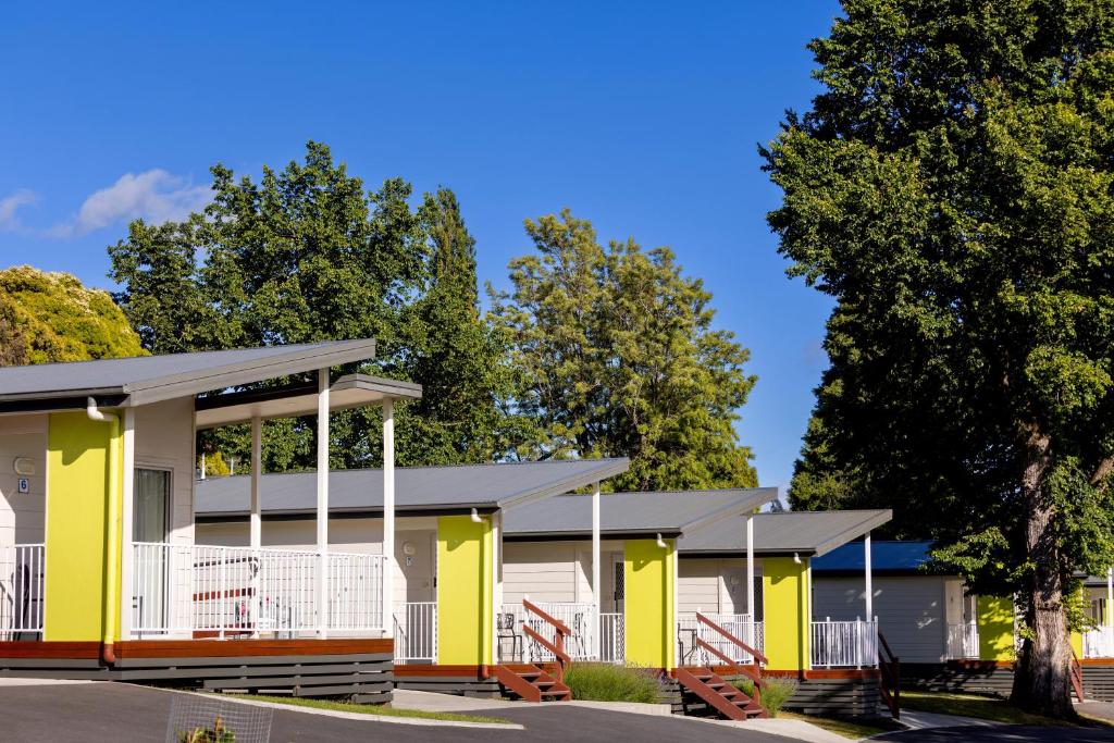 a row of houses with yellow and white at BIG4 Launceston Holiday Park in Launceston