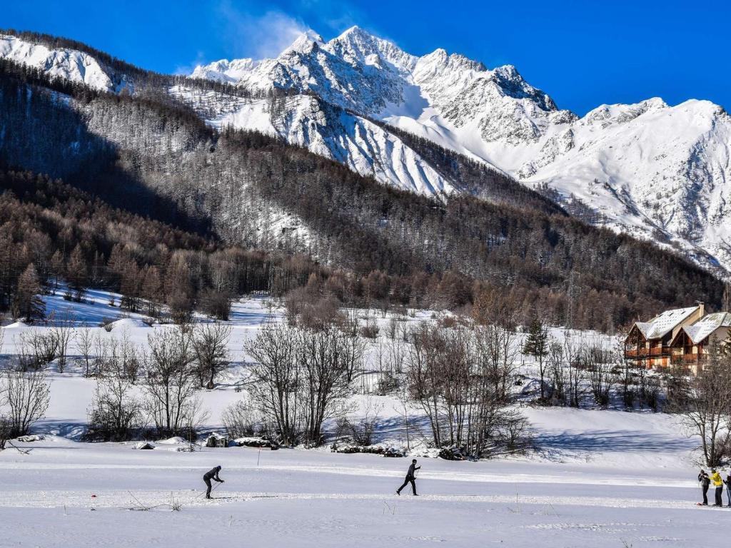 two people skiing in the snow in front of a mountain at Appartement Serre Chevalier, 1 pièce, 4 personnes - FR-1-330F-119 in Serre Chevalier