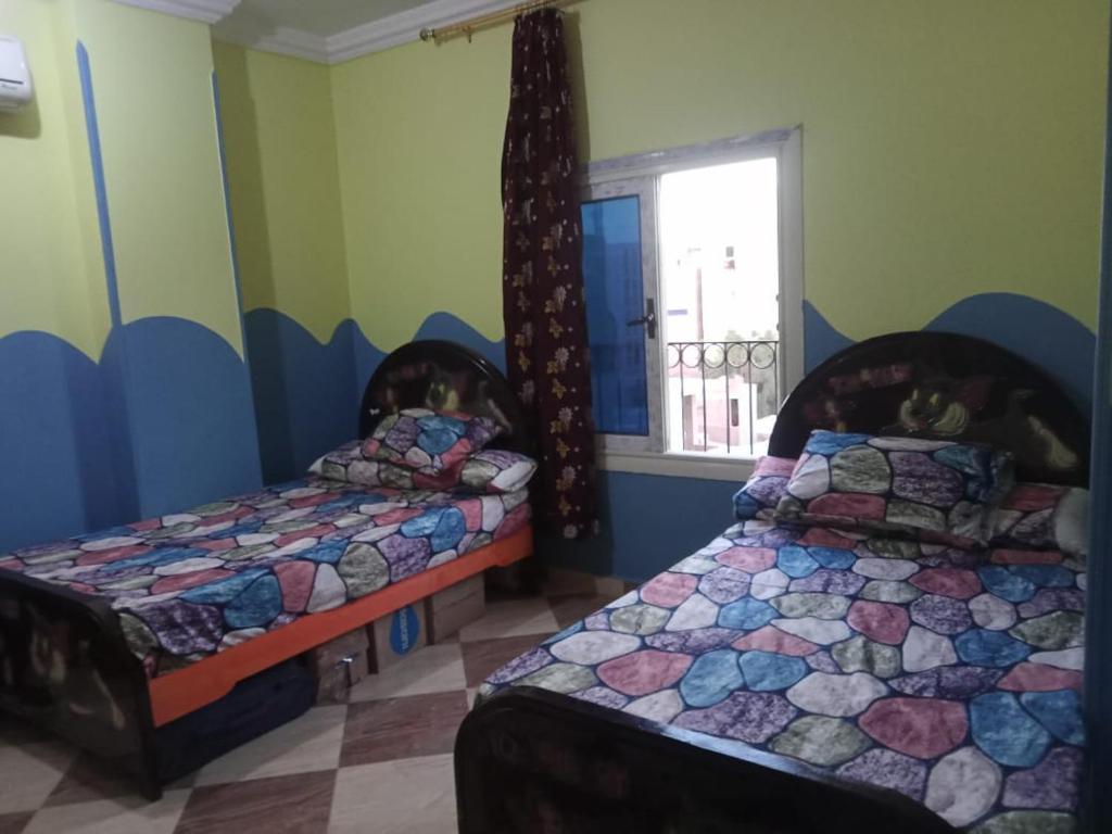 1 Schlafzimmer mit 2 Betten und einem Fenster in der Unterkunft IKEA Flats in Hurghada