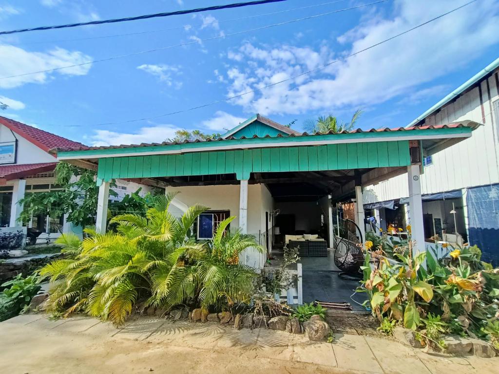 un edificio con techo verde y palmeras en Sam's Guesthouse M'Pai Bay, en Koh Rong Sanloem