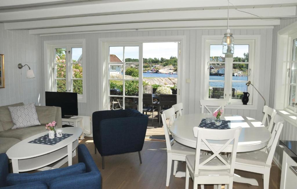 un soggiorno con tavolo, sedie e divano di Holiday Home Flekkerøy Paulen Ii a Møvik