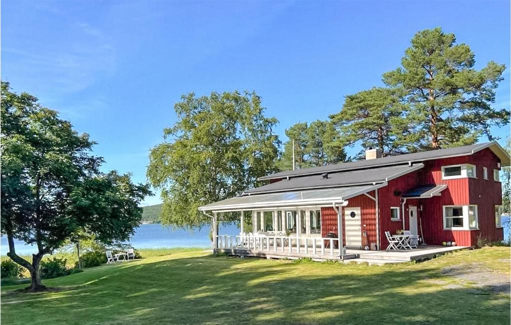 a red house with a porch on a lawn at Cozy Home In Domsj With Kitchen in Domsjö