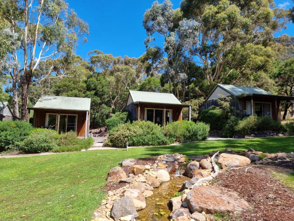 a house with a garden and a creek in front of it at D'Altons Studios in Halls Gap