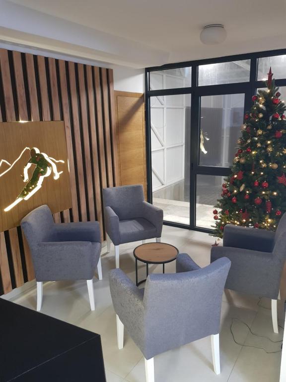 a christmas tree in a waiting room with chairs and a christmas tree at Apartman Skyline Kopaonik in Kopaonik