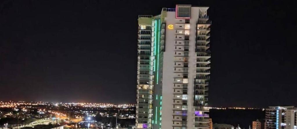 a tall building is lit up at night at One bed Harbour and city views apartment in Darwin