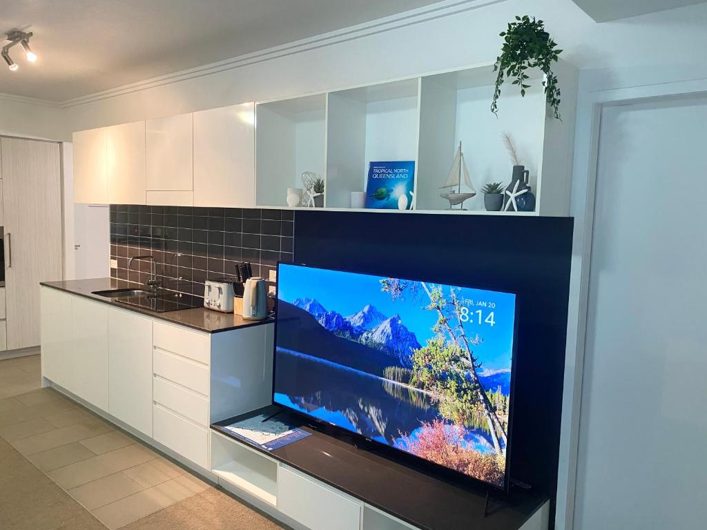 a kitchen with a large flat screen tv on a counter at Cozy Cool Getaway in Townsville