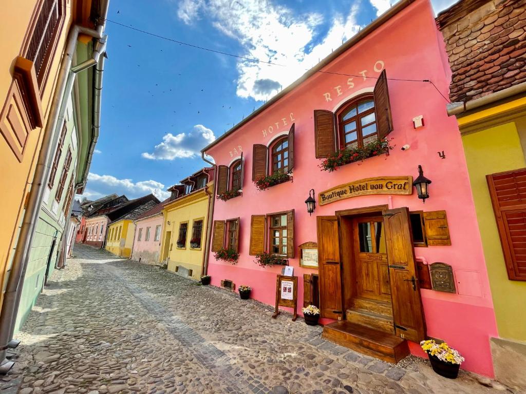 eine Straße mit bunten Gebäuden in einer Kopfsteinpflasterstraße in der Unterkunft Boutique Hotel von Graf in Sighişoara