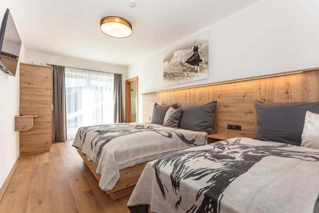 1 dormitorio con 2 camas y ventana en Lienbichl en Saalbach Hinterglemm