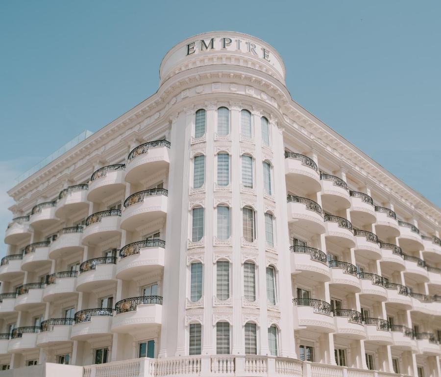 um grande edifício branco com um cartaz em Hotel Empire Albania em Durrës