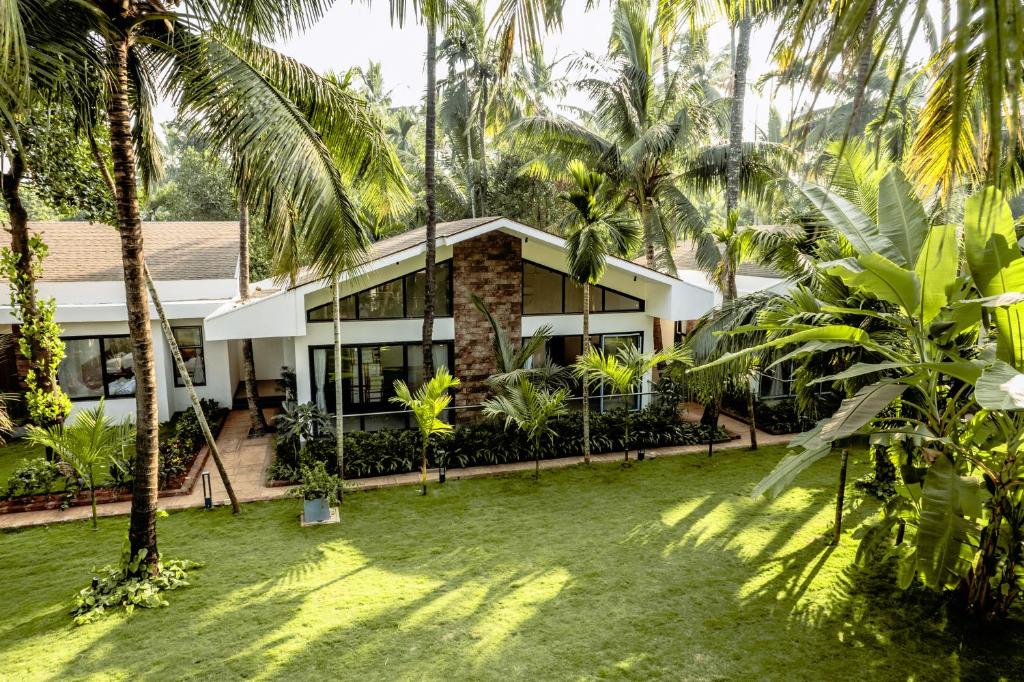 戴维格Coco Palms Resort, Diveagar的一栋门前有棕榈树的房子