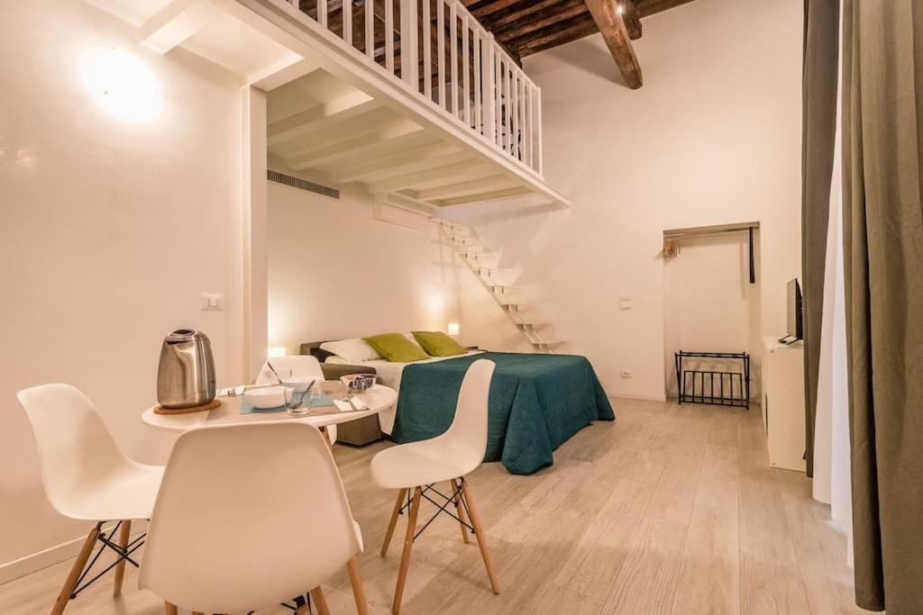 uma sala de estar com uma cama, uma mesa e cadeiras em Ca' Nova @San Marco em Veneza