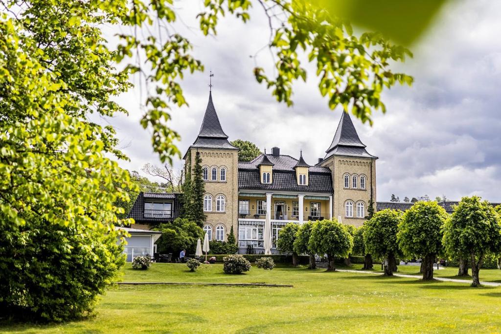 un gran edificio con dos torres en un campo de césped en Hotel Refsnes Gods - by Classic Norway Hotels, en Moss
