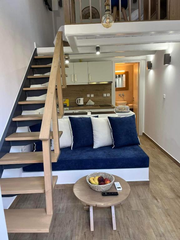 a living room with a blue couch and a staircase at OASIS rooms in Karistos