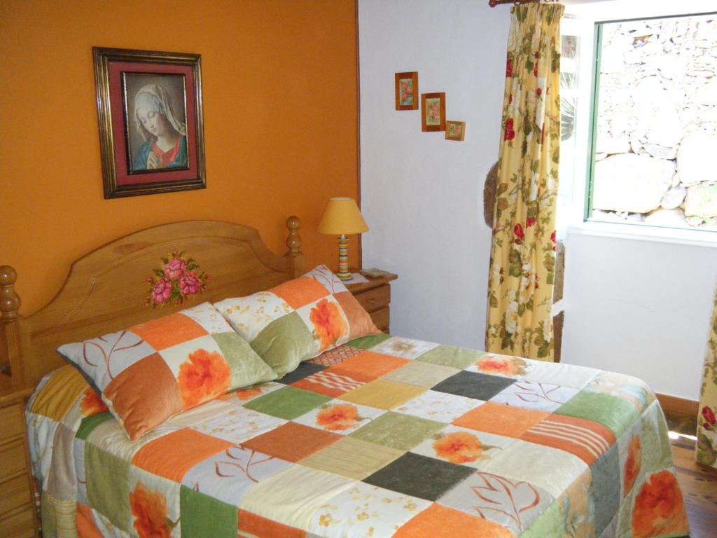 a bedroom with a bed with a quilt on it at Casa Rural Virgen del Rosario in San Juan de la Rambla