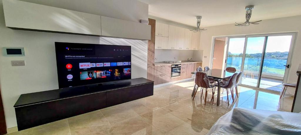 a kitchen with a large tv and a table and chairs at Valley View in Qrendi