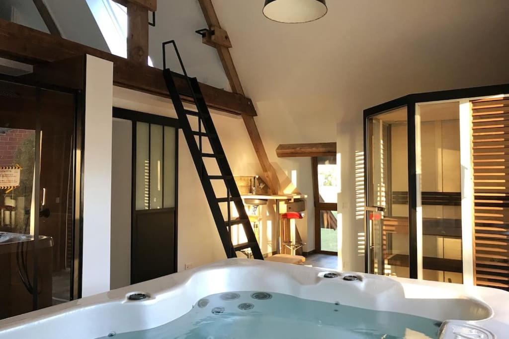 bañera en una habitación con escalera en Spa privatif à la ferme - Haut de gamme - Atypique en Bois-Grenier