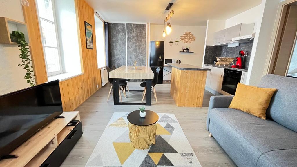een woonkamer met een bank en een tafel bij Le Coeur de Pontarlier in Pontarlier