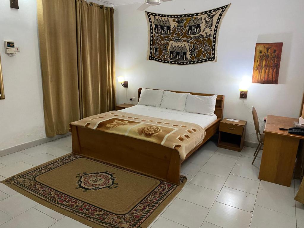 1 dormitorio con 1 cama con alfombra en el suelo en Casablanca Guest Inn, en Takoradi