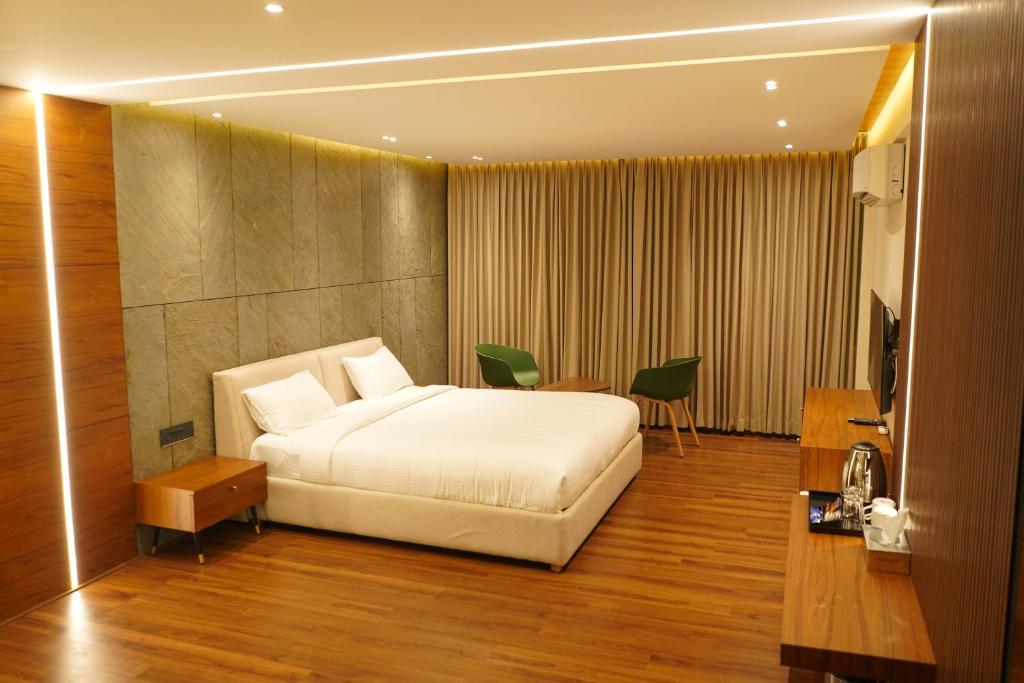 Un dormitorio con una gran cama blanca y una mesa en Hotel Bekal International en Kāsaragod