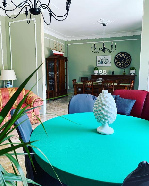 a dining room with a green table and chairs at B&B Fiorisol in Augusta