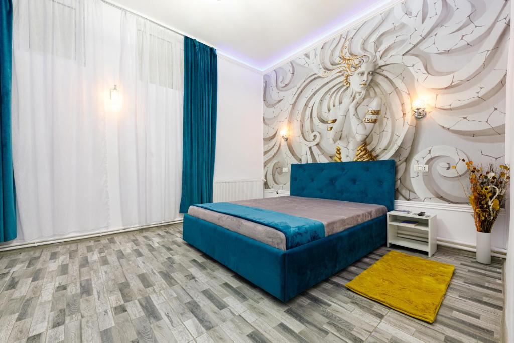 een slaapkamer met een blauw bed en een muur bij Joy City Stay Pacha in Timişoara