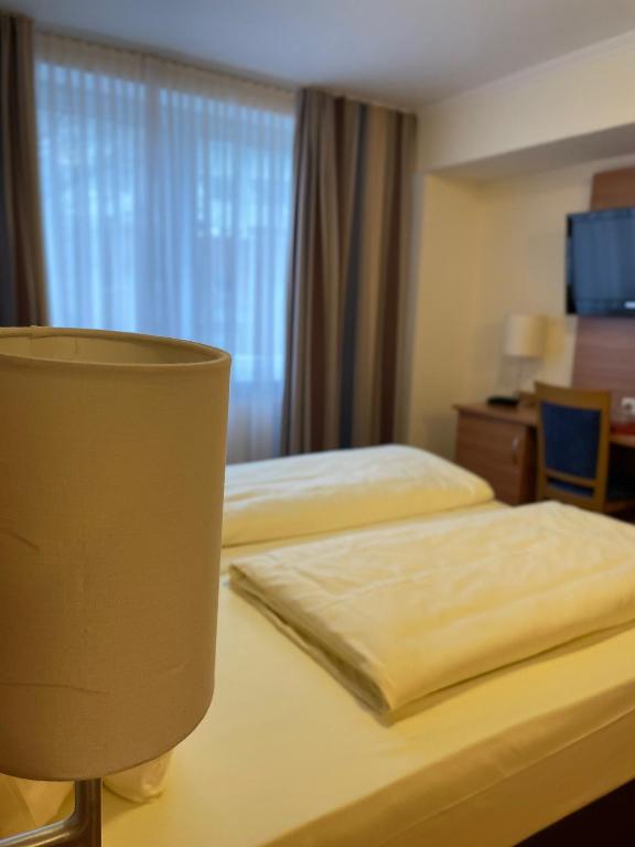 Postel nebo postele na pokoji v ubytování Hotel Harburger Hof