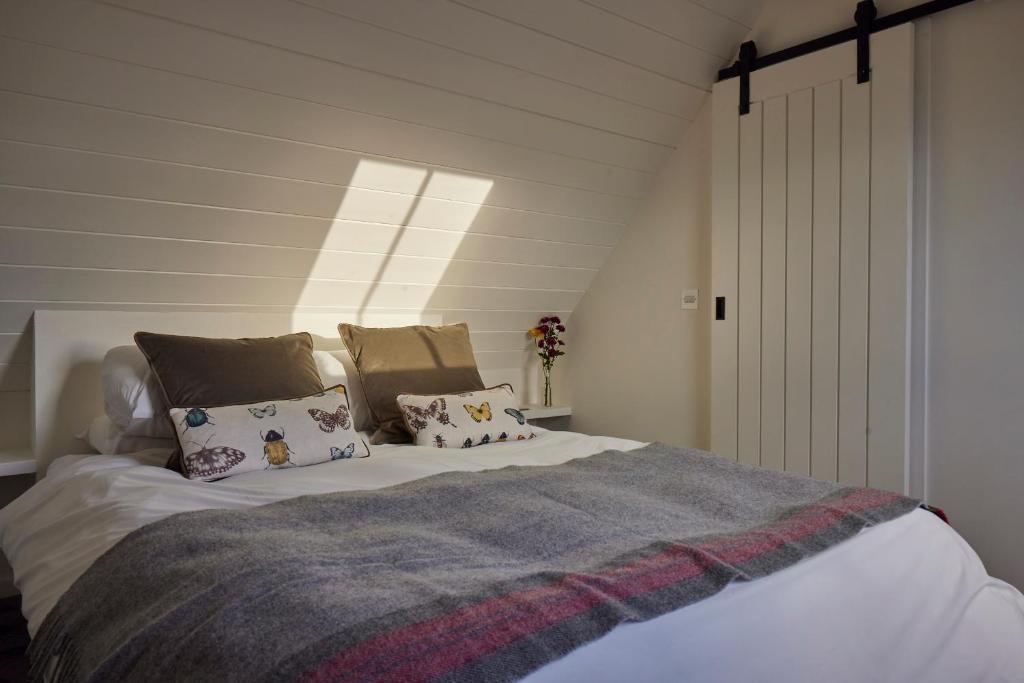 een slaapkamer met een groot bed met kussens bij Monkstadt No 10 The Horse Walk in Totscore