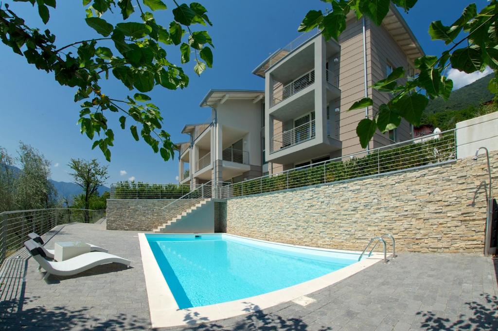 uma casa com piscina em frente a um edifício em Residenza Simona em Mezzegra