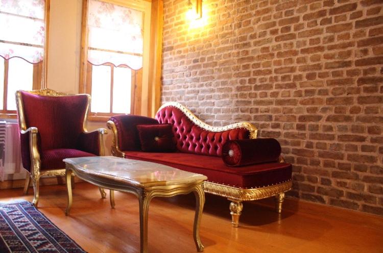ein Wohnzimmer mit einem roten Sofa und 2 Stühlen in der Unterkunft Authentic Turkish Home Family Room in Istanbul