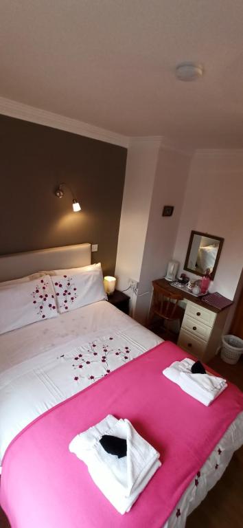 a bedroom with a large bed with a pink blanket at The Ferry Boat in Portmagee