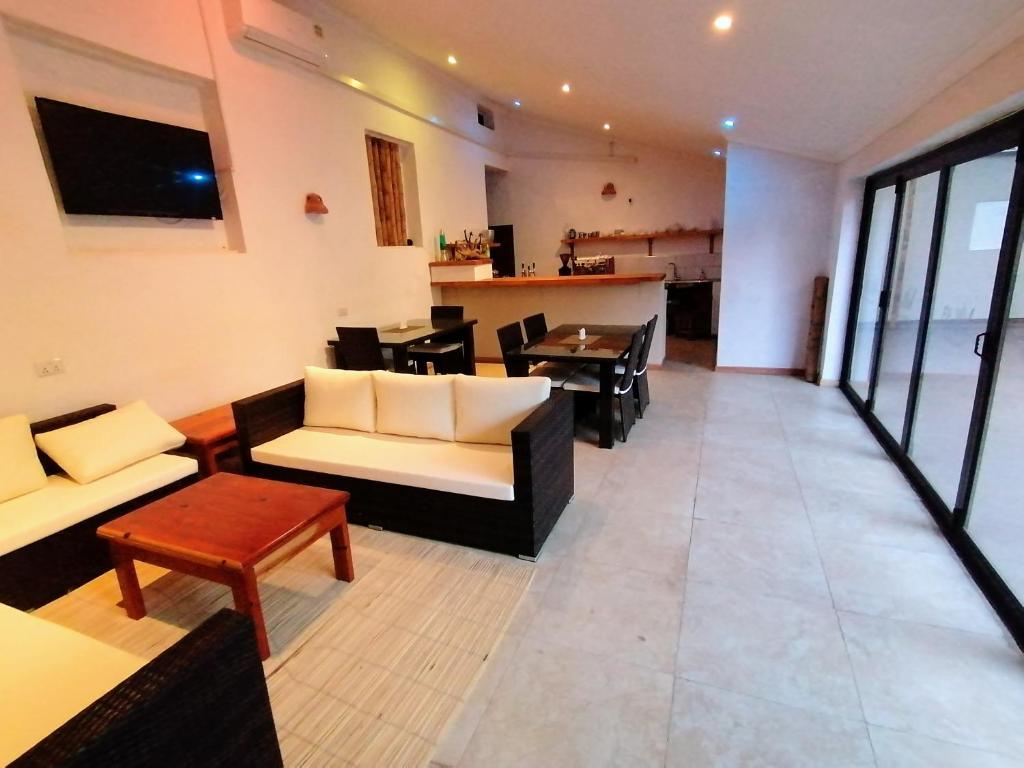 a living room with couches and a table and a kitchen at Villa 33 in Blantyre