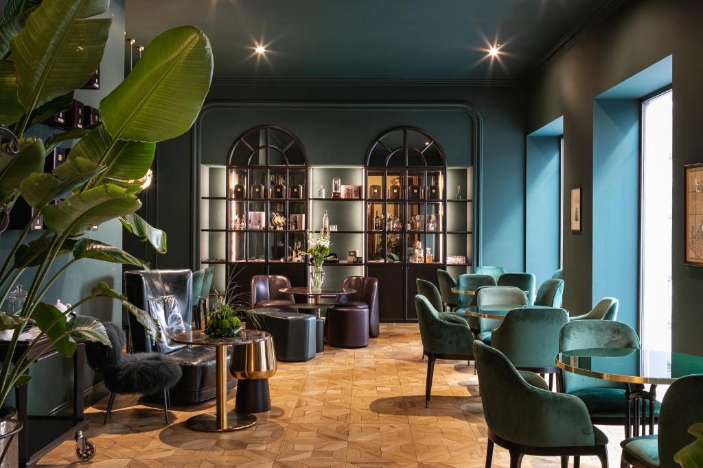 un bar avec des chaises et des tables vertes dans une pièce dans l'établissement Hotel Continentale, à Trieste