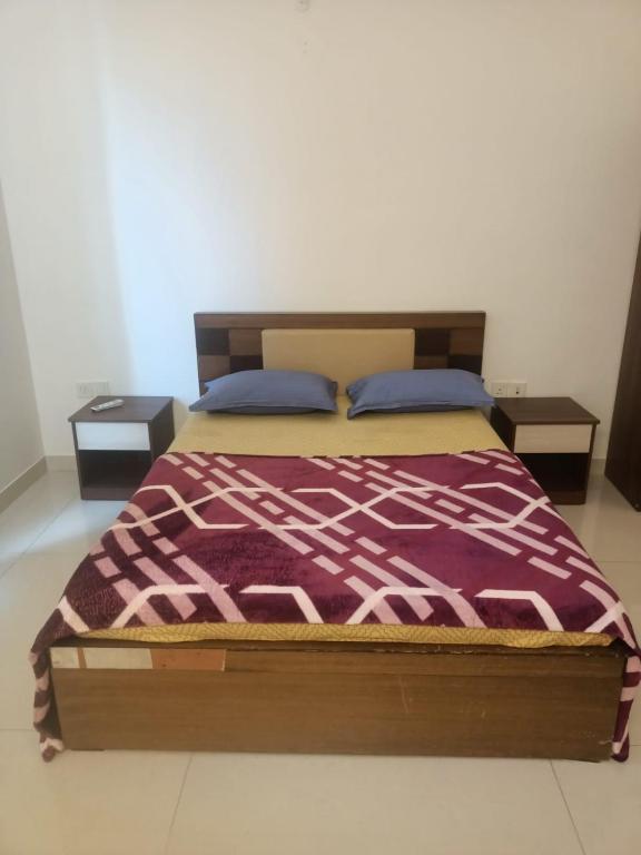a bed in a room with two nightstands and a bedspread at Royal Nest - Luxury Stay in Pune