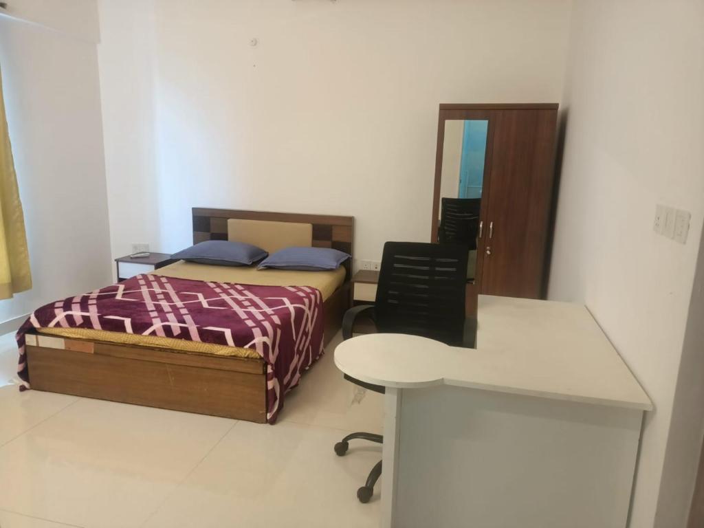 a bedroom with two beds and a desk and a table at Royal Nest - Luxury Stay in Pune