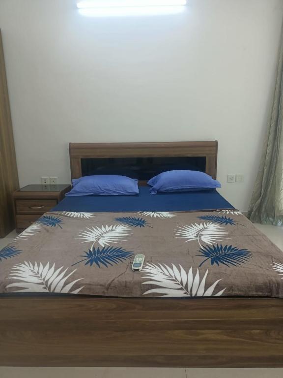 a bed with a blue and white blanket on it at Royal Nest - Luxury Stay in Pune