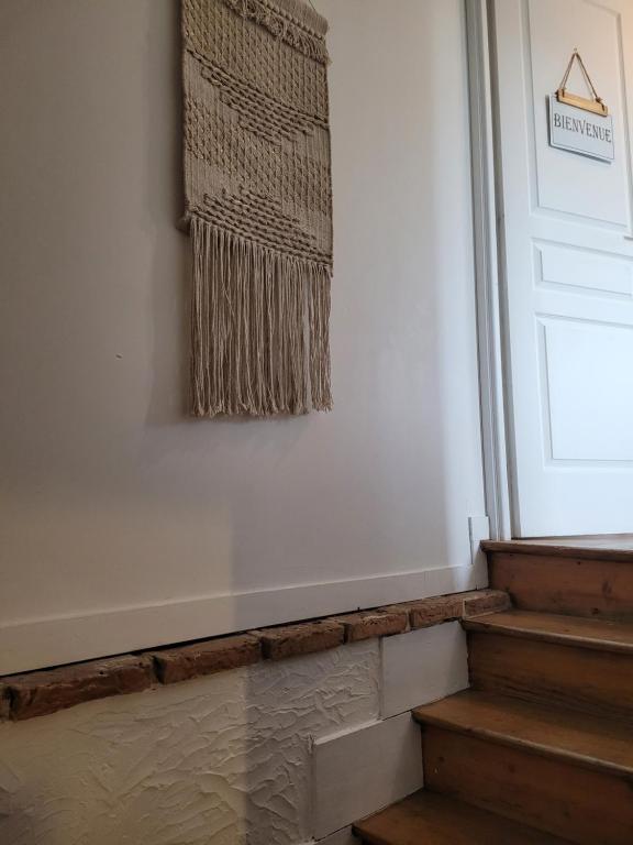 a rug hanging on a wall next to some stairs at LA P&#39;TITE YPORTAISE in Yport