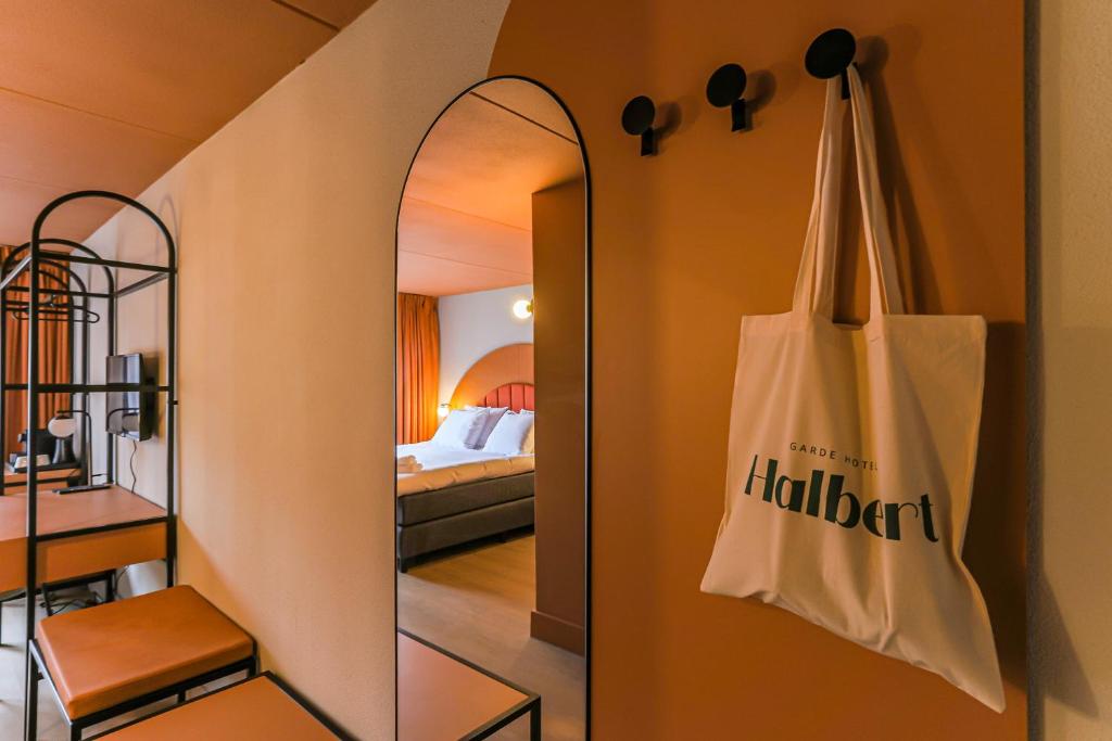 un espejo colgado en una pared junto a un dormitorio en Hotel Halbert en Groningen