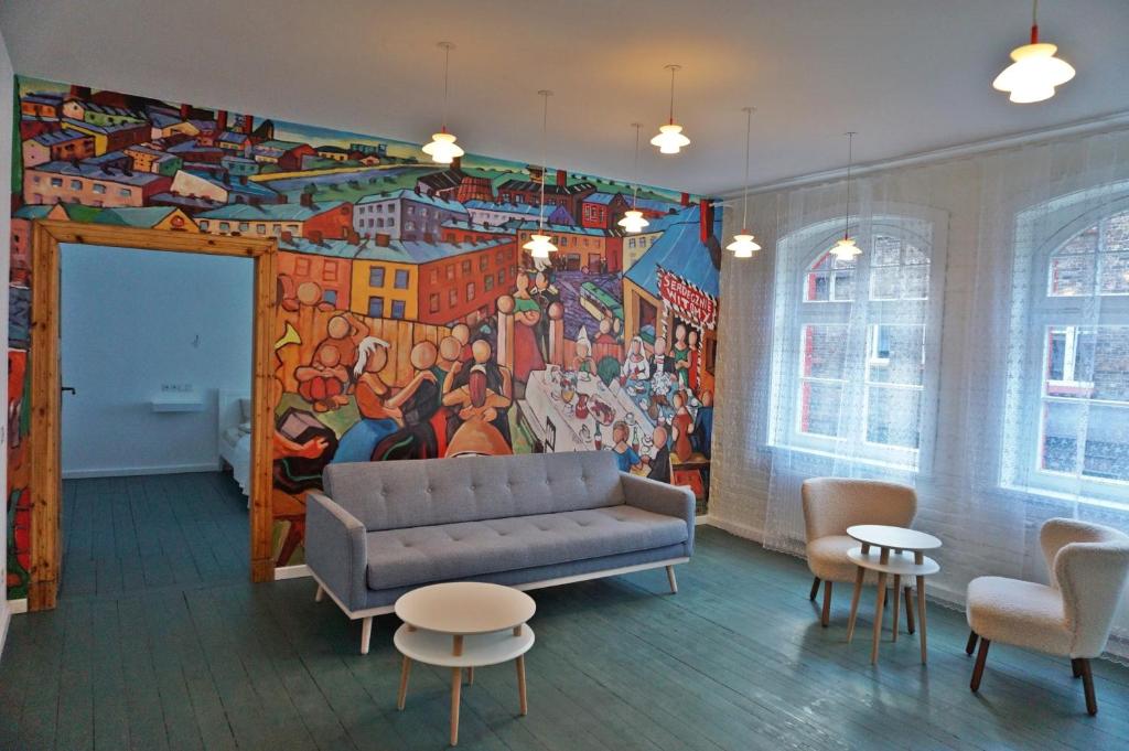 una sala de estar con sofá y una pintura en la pared en Muralowy apartament Katowice Nikiszowiec en Katowice