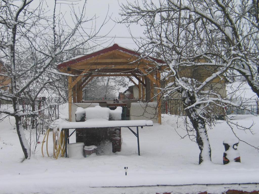 un cenador con nieve en un patio en Réti Tanya Vendégház, en Kerecseny