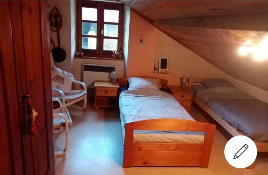 a bedroom with two beds in a attic at Chambre dans maison a la campagne in Pressins