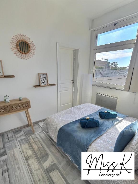 Schlafzimmer mit einem Bett, einem Schreibtisch und einem Fenster in der Unterkunft L&#39;Héritan de Miss.K Conciergerie in Mâcon
